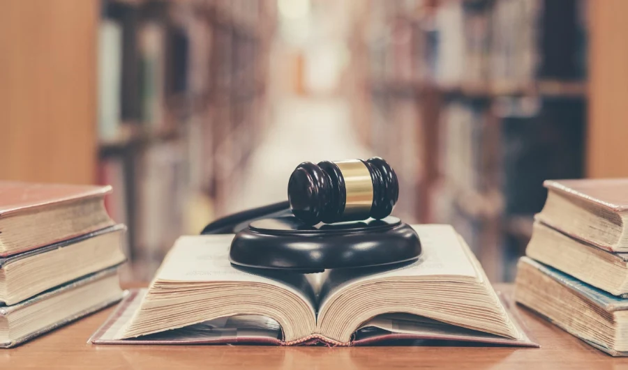 textbooks in law library with judge gavel on top